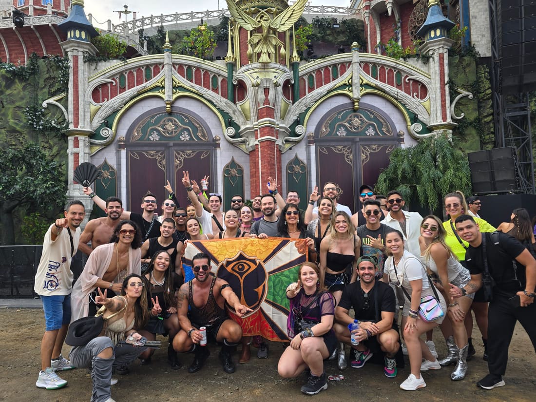 Grupo da Never Ends com a bandeira da Tomorrowland diante de um dos palcos da edição Adscendo, no Parque Maeda