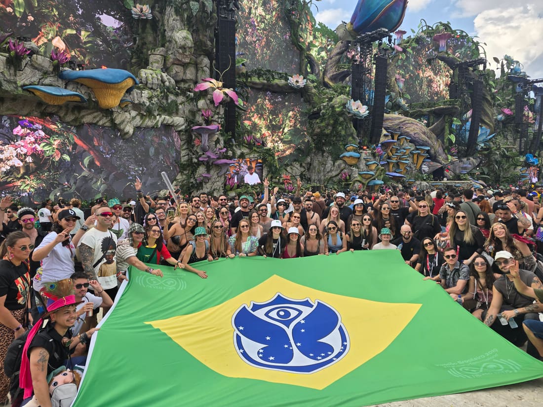 Galera da Never Ends abrindo a bandeira gigante do Brasil com o símbolo da Tomorrowland diante do Mainstage LIFE, no Parque Maeda